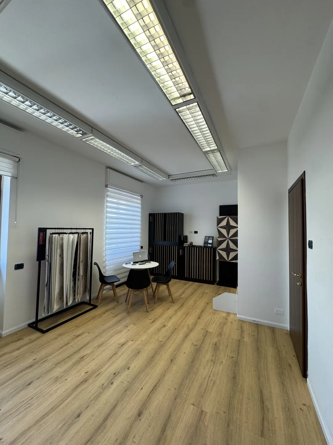 La sala dello showroom 2EFFE Group a Rozzano, con il pavimento in SPC effetto rovere e gli espositori dei campioni