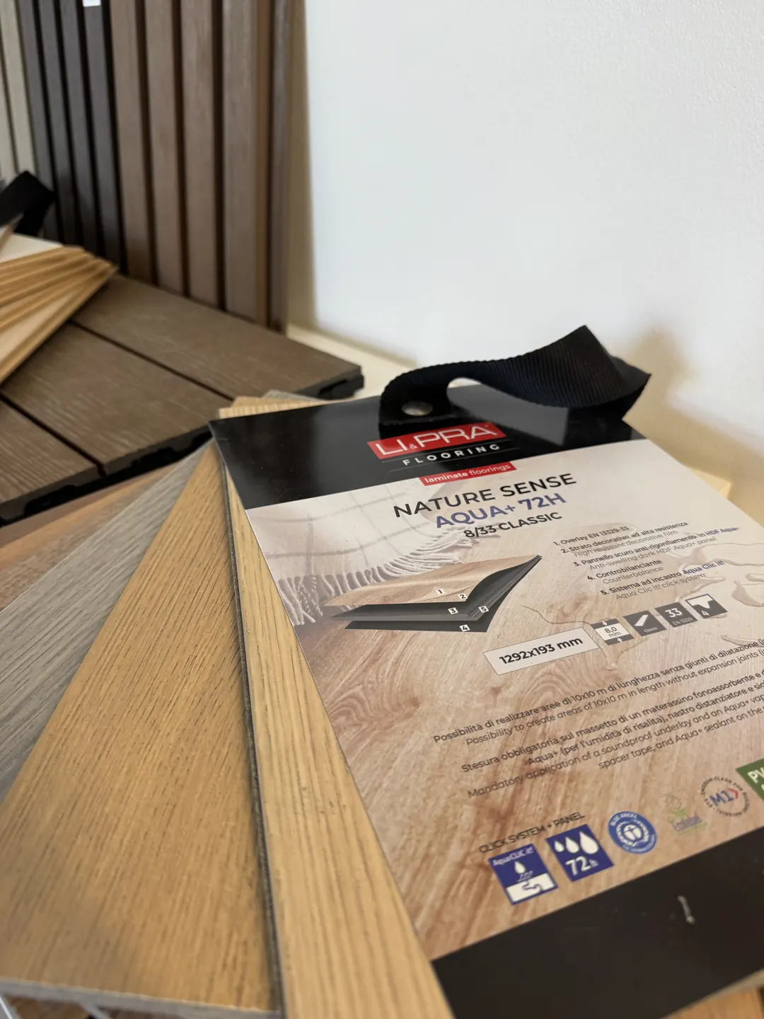 Campioni di pavimento SPC effetto legno visti da vicino, con il bordo dell'incastro a click e la scheda tecnica