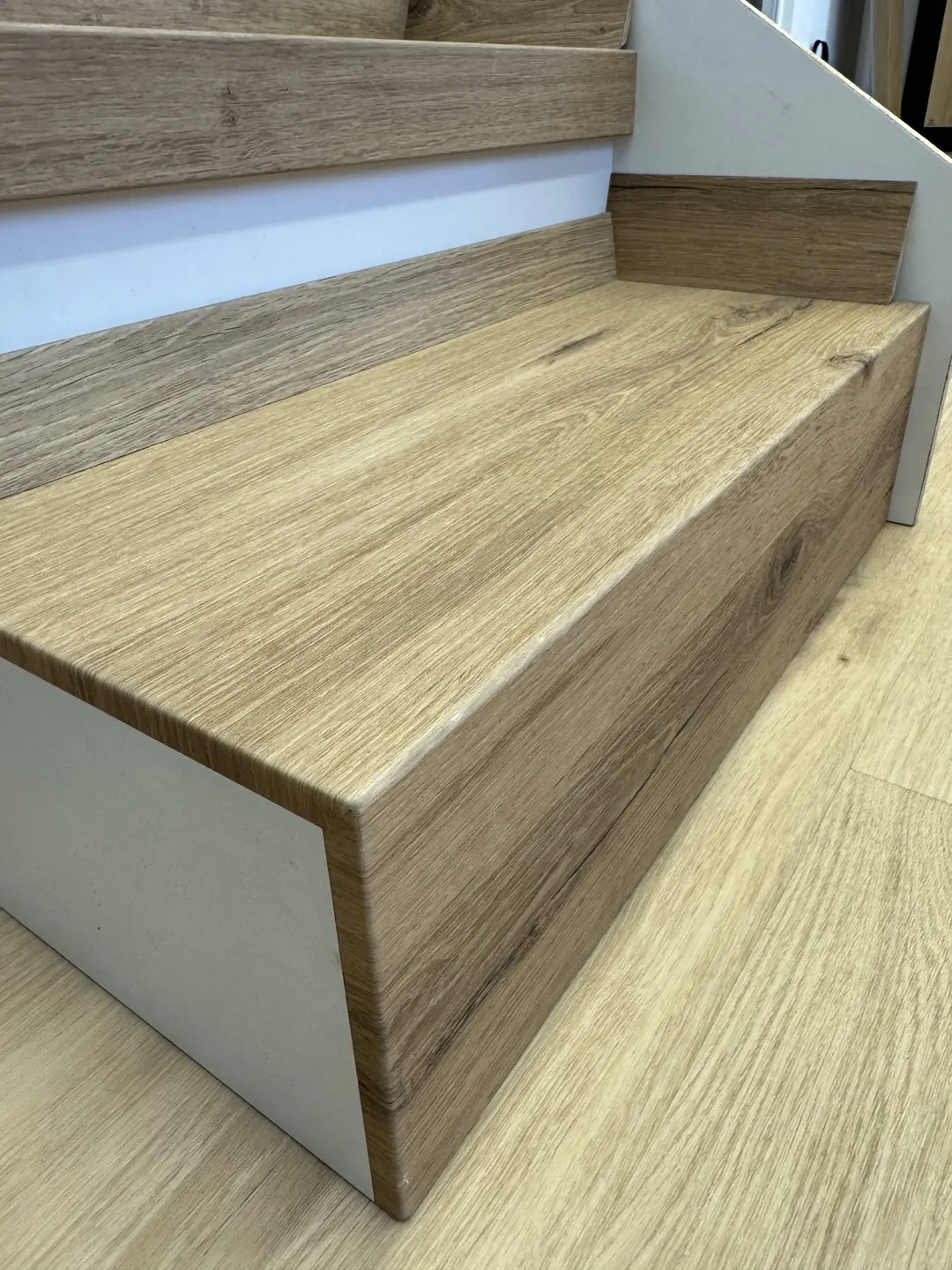 Gradini rivestiti in SPC effetto rovere, con il bordo del gradino rifinito, nello showroom 2EFFE Group